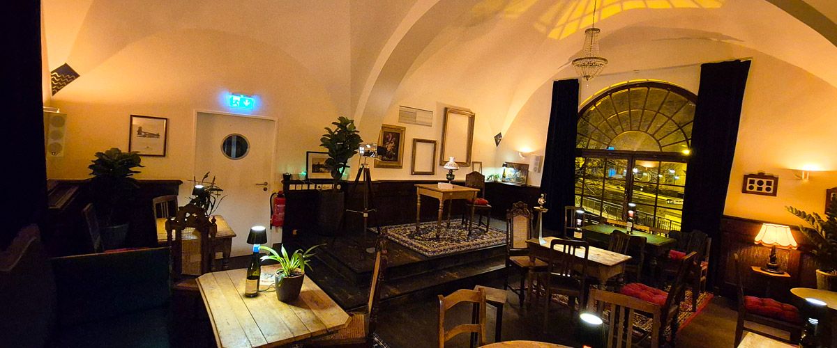 Einladendes Ambiente mit Beleuchtung, Holztischen und Wohlfühlatmosphäre